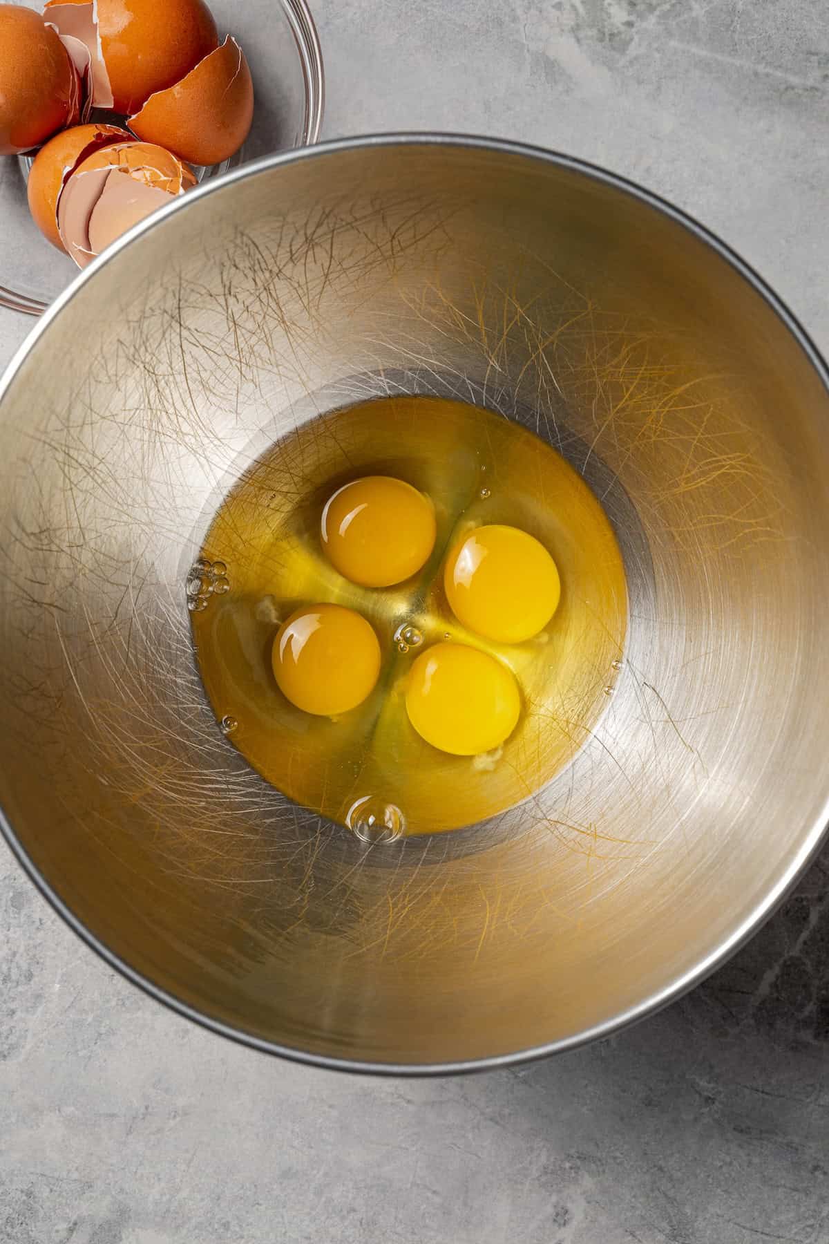 Make fudgy Nutella brownies by whipping eggs and adding Nutella. That's it! These brownies are extra chocolatey and naturally gluten-free. Four eggs added to a metal mixing bowl.