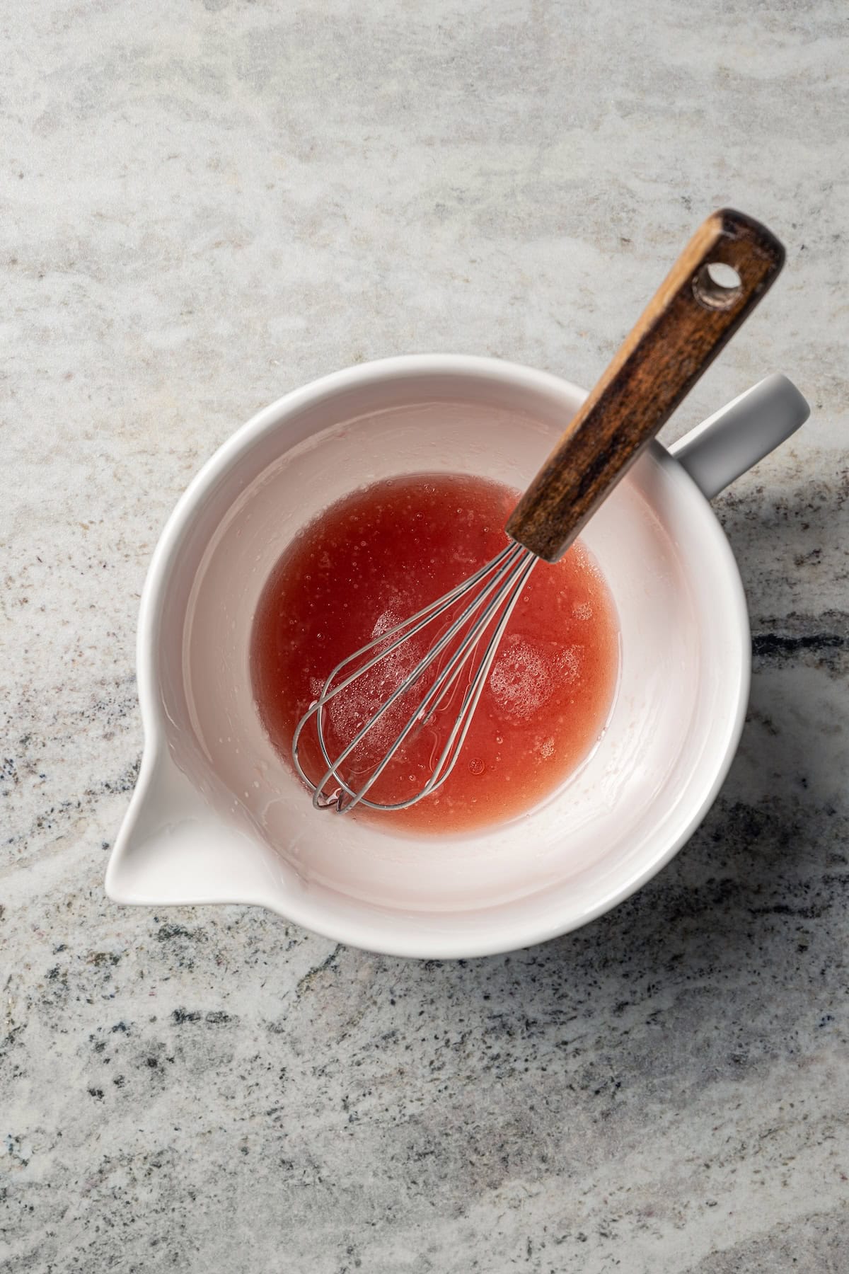 Red wine vinaigrette in a bowl with a whisk.