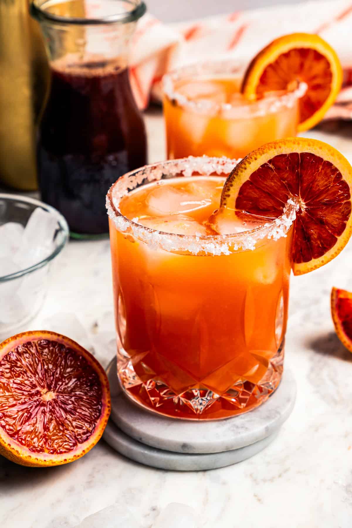 Blood orange margaritas garnished with a salt rim and a slice of orange.