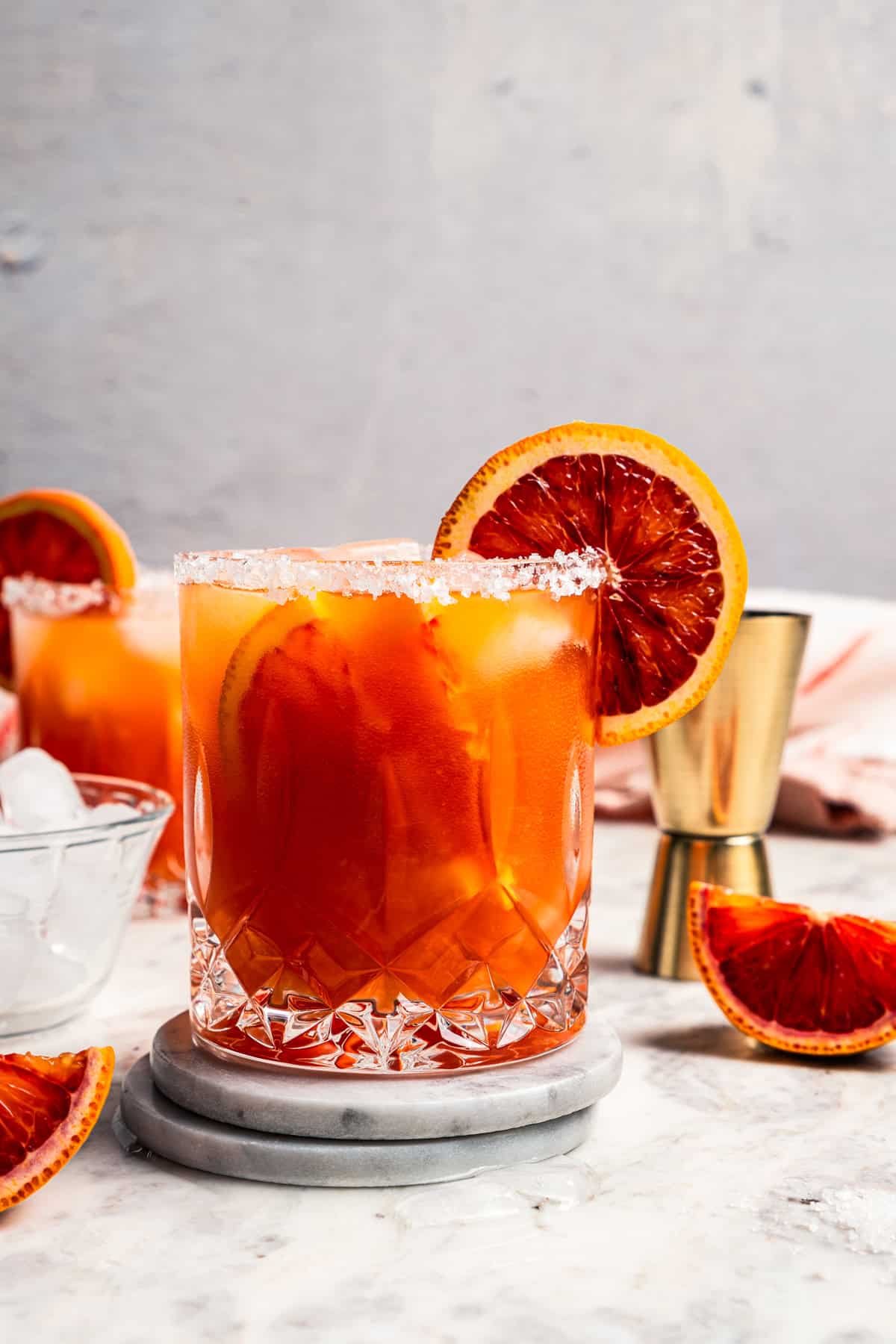 Blood orange margaritas garnished with a salt rim and a slice of orange.