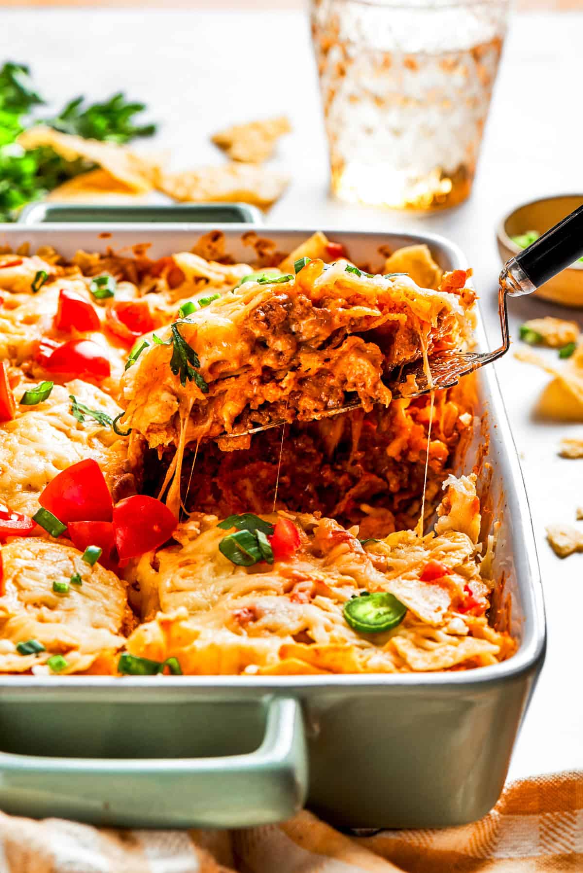 Lifting up a slice of casserole from a baking dish.