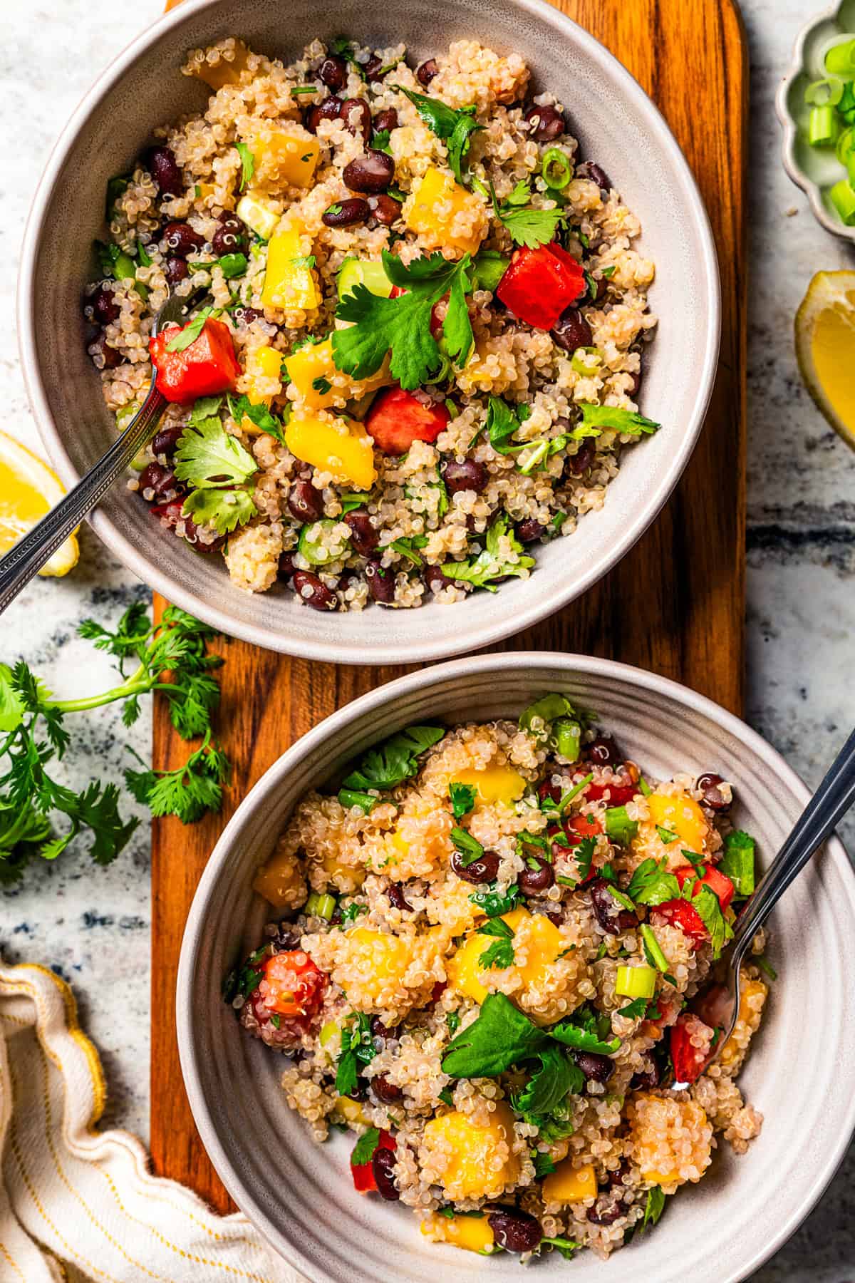 bowls of quinoa salad with black beans and mango.
