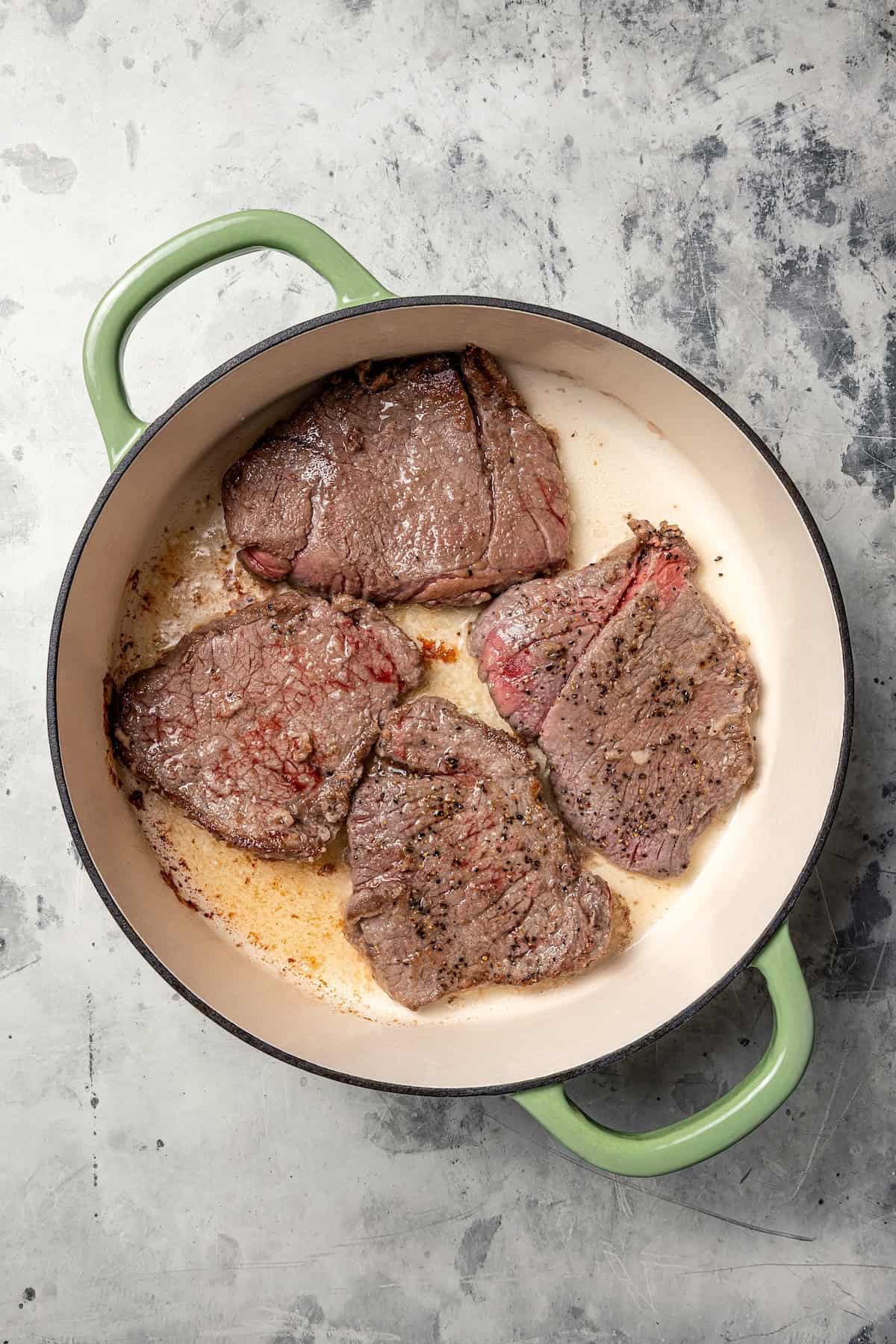 This Swiss steak recipe with gravy is a comforting dinner with juicy beef slow-braised in a rich tomato sauce and served over mashed potatoes. Browned steaks in a Dutch oven.
