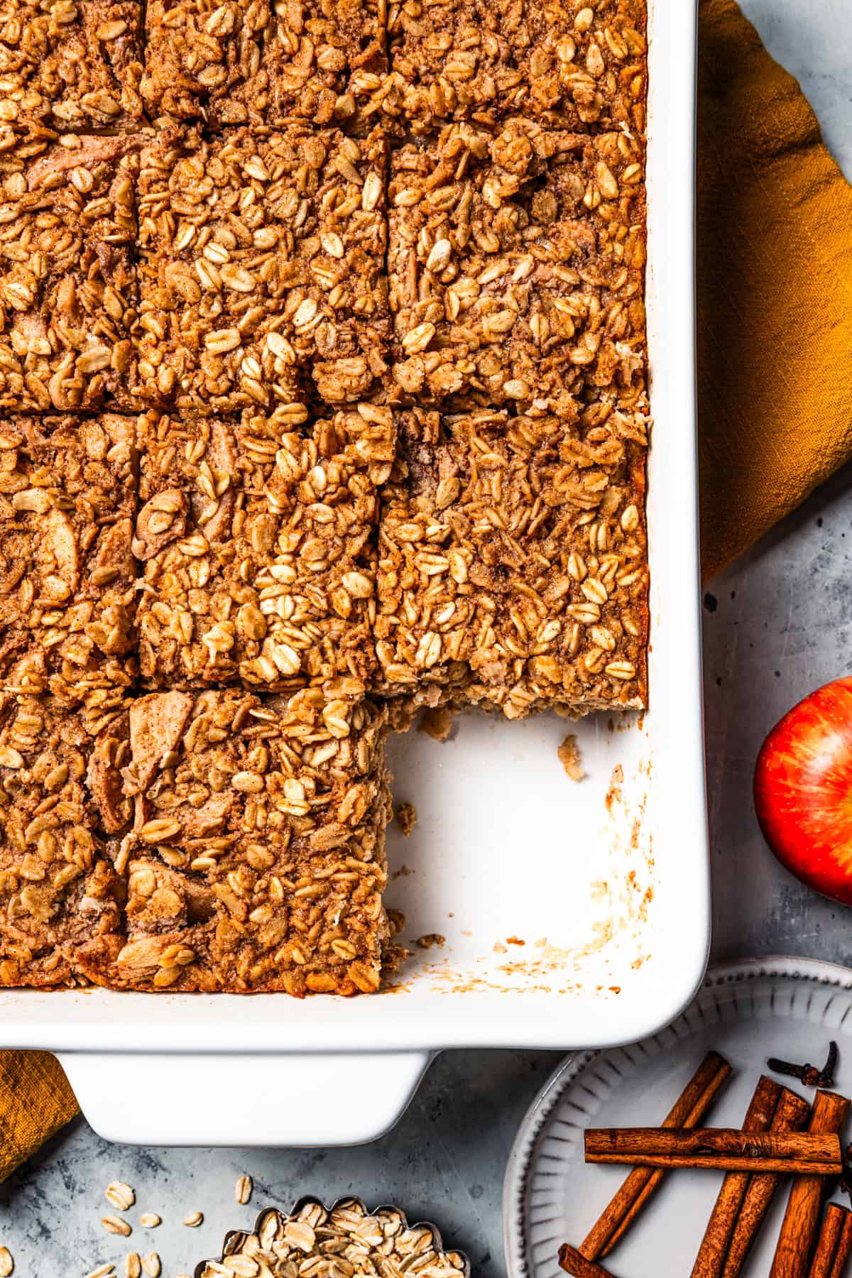 Apple baked oatmeal in a casserole dish, cut into squares.