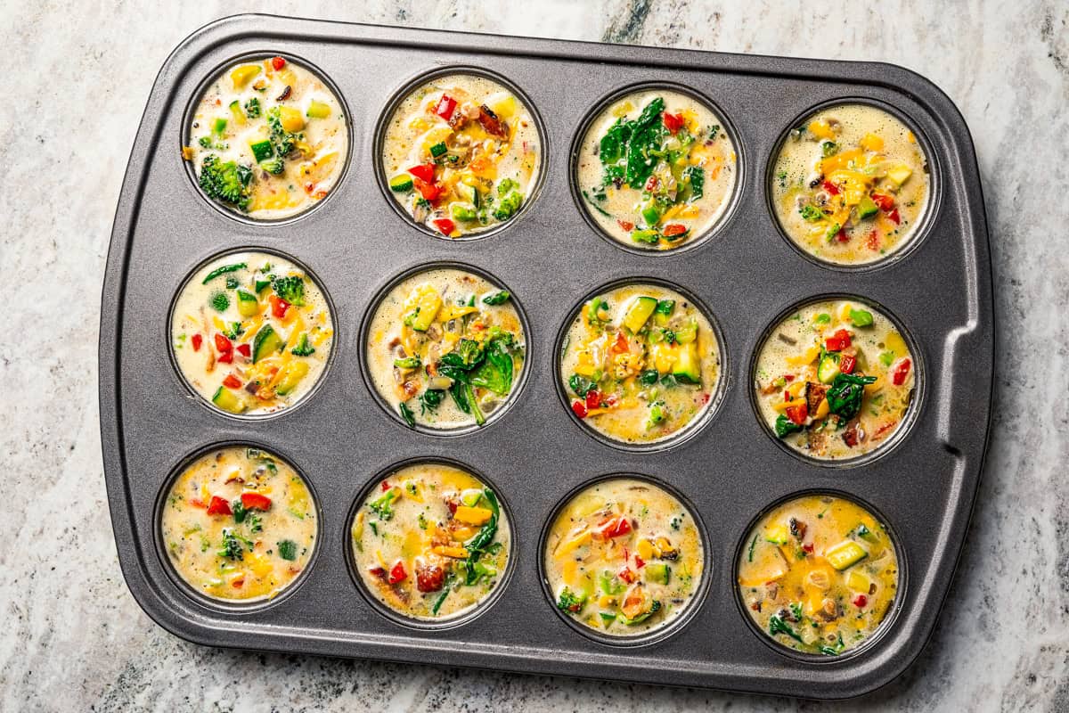 This Starbucks-inspired egg bites recipe with cottage cheese and veggies is quick to bake in a muffin tin. It's an easy, on-the-go breakfast! Egg mixture poured into the cups of a muffin pan to make egg bites.