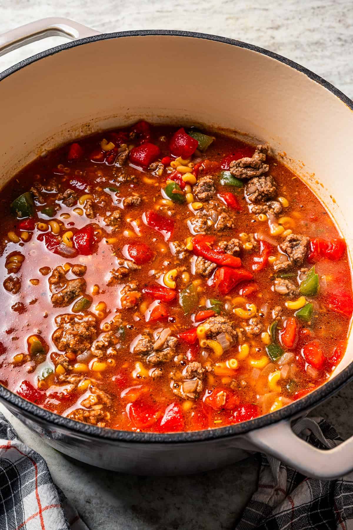 Goulash ingredients combined and cooking in a pot.