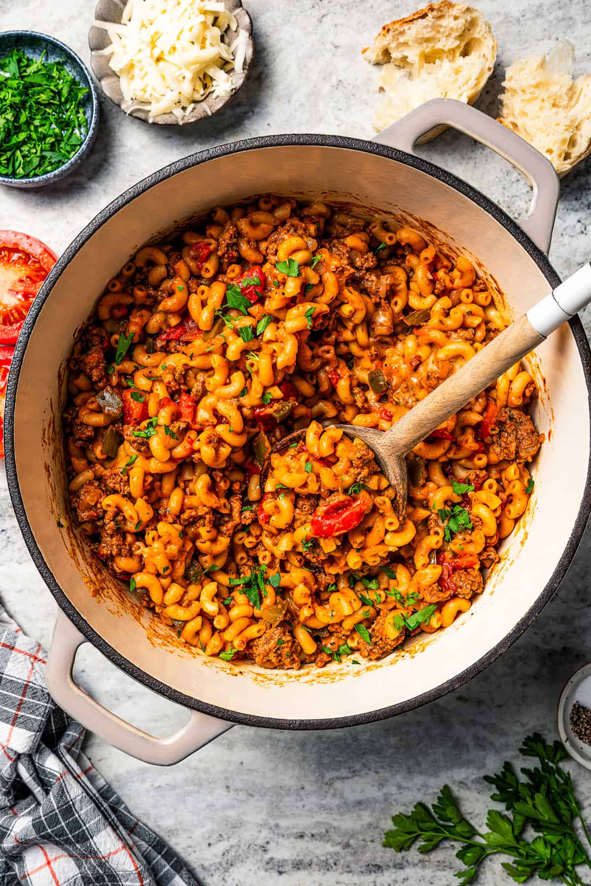 Goulash in a pot with a wooden spoon stirring through it.