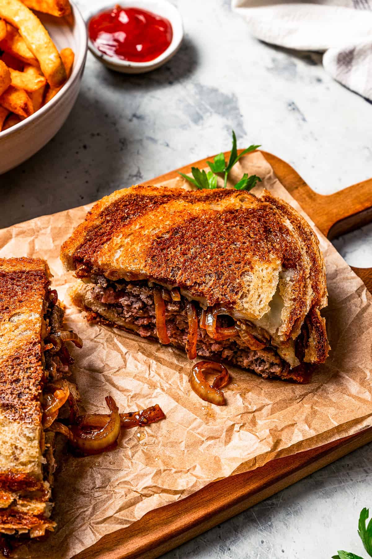 A patty melt sandwich cut in half.