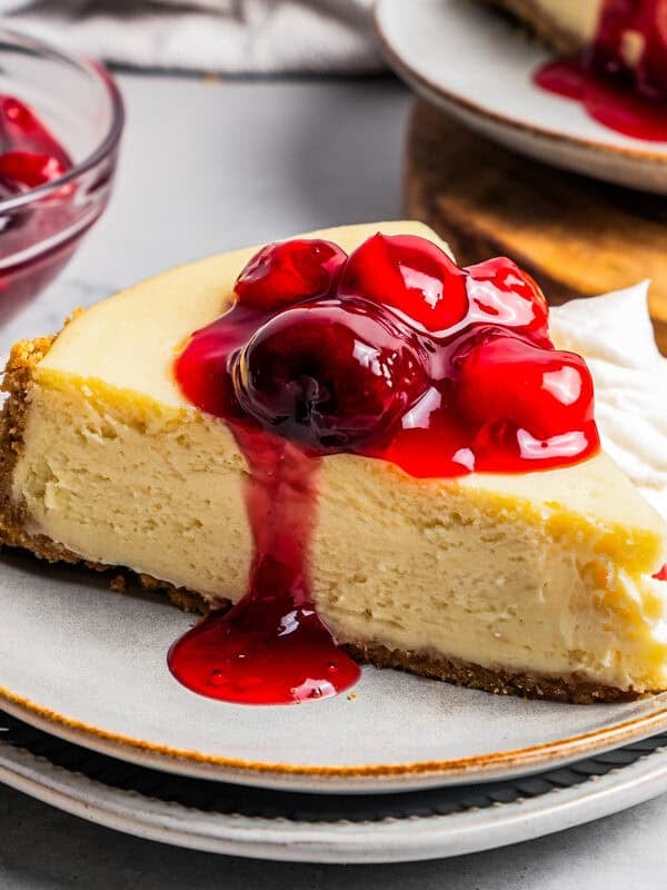 Cherry cheesecake sliced served on a plate.