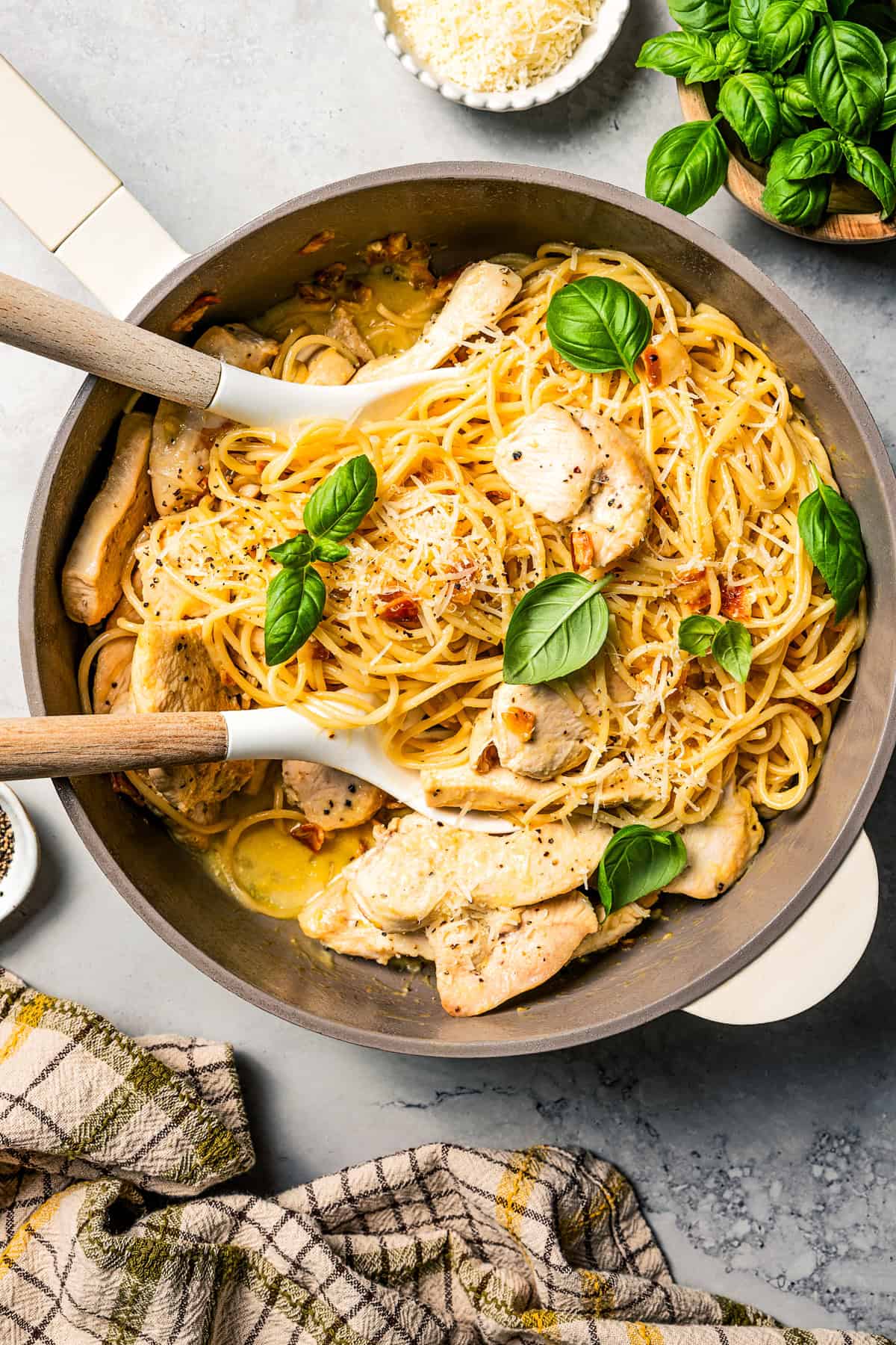 Make the best chicken carbonara in 30 minutes! This is a creamy pasta with parmesan, pancetta, and tender chicken, perfect for weeknights. Chicken carbonara in a pot with two serving spoons.