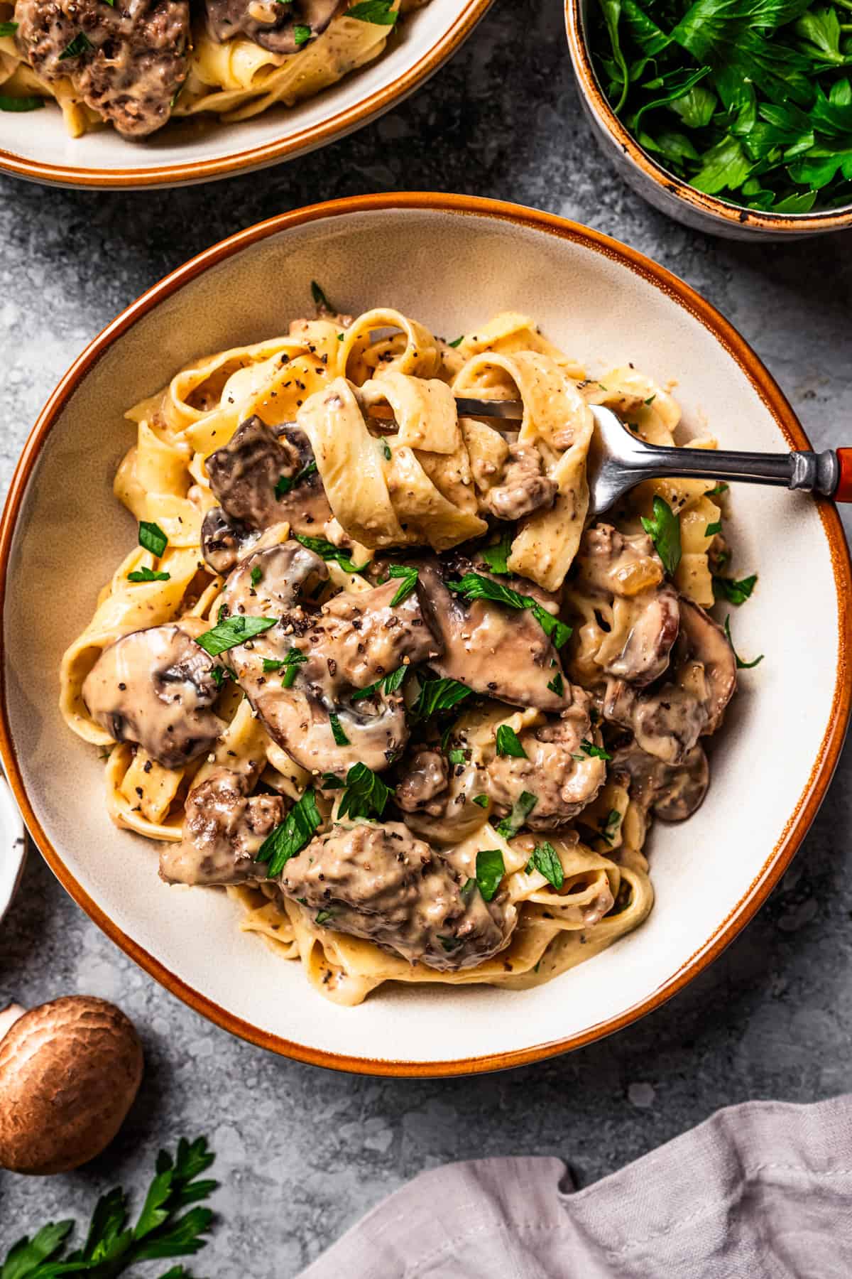This easy hamburger stroganoff recipe is quick to make in one skillet! Creamy, cozy, and budget-friendly, it's a favorite ground beef dinner. Creamy hamburger stroganoff served over egg noodles in a bowl.