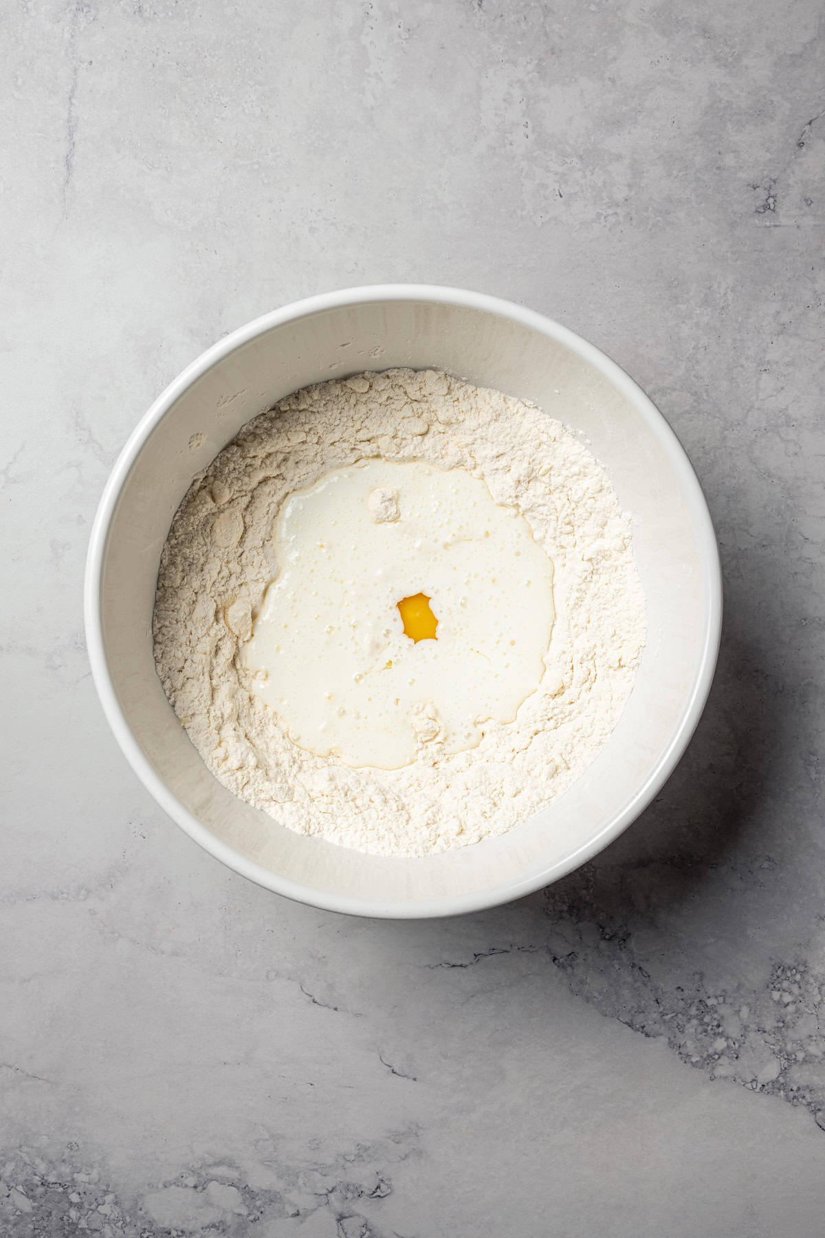 Wet ingredients added to a well made in the bowl of dry ingredients.