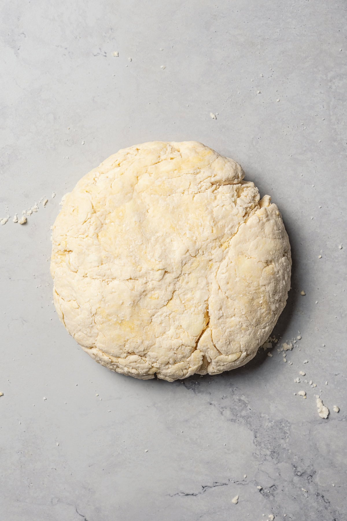 A ball of biscuit dough on a countertop.