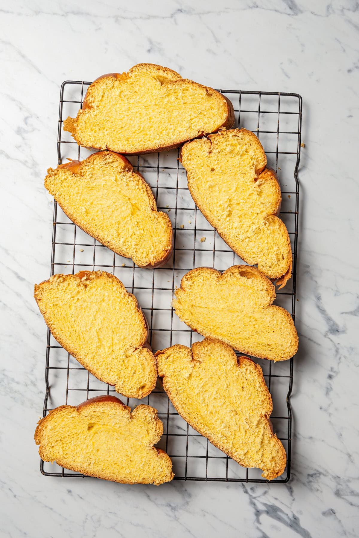 Make thick, fluffy challah bread French toast soaked in an eggy custard with cinnamon, vanilla, and grated nutmeg. The best weekend breakfast! Slices of challah bread arranged on a wire rack.
