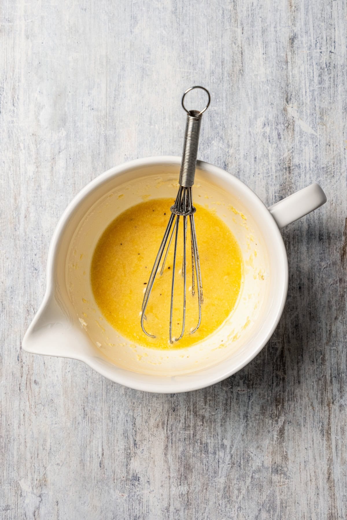 This chicken and bacon pasta is a 20-minute meal with tender linguine, juicy chicken, bacon, and parmesan in a creamy, Carbonara-style sauce. Egg sauce whisked together in a bowl.