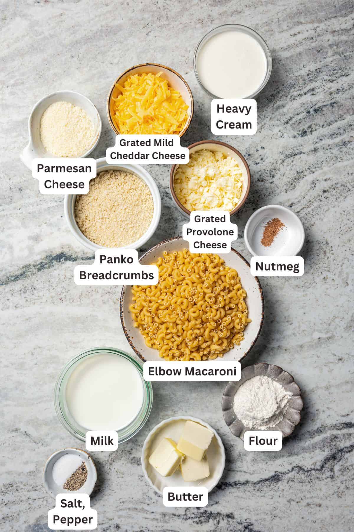 This easy baked mac and cheese recipe has tender pasta and a creamy, melty homemade cheese sauce, baked until golden and bubbly in the oven! Homemade mac and cheese ingredients with text labels overlaying each ingredient.