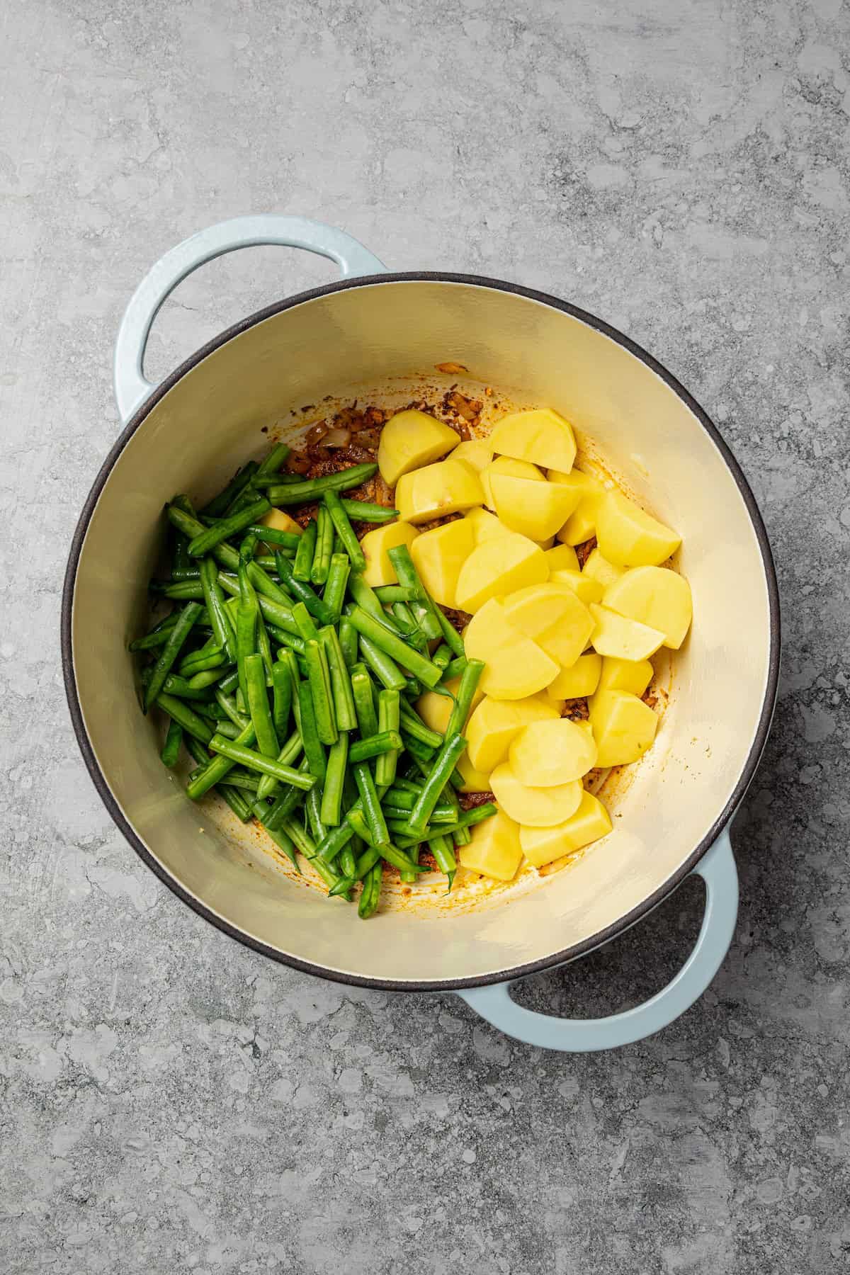 Braised potatoes are slow-cooked with tender green beans and tomatoes in this easy, one-pot Macedonian dish that warms from the inside out. Potatoes and green beans combined in a pot.