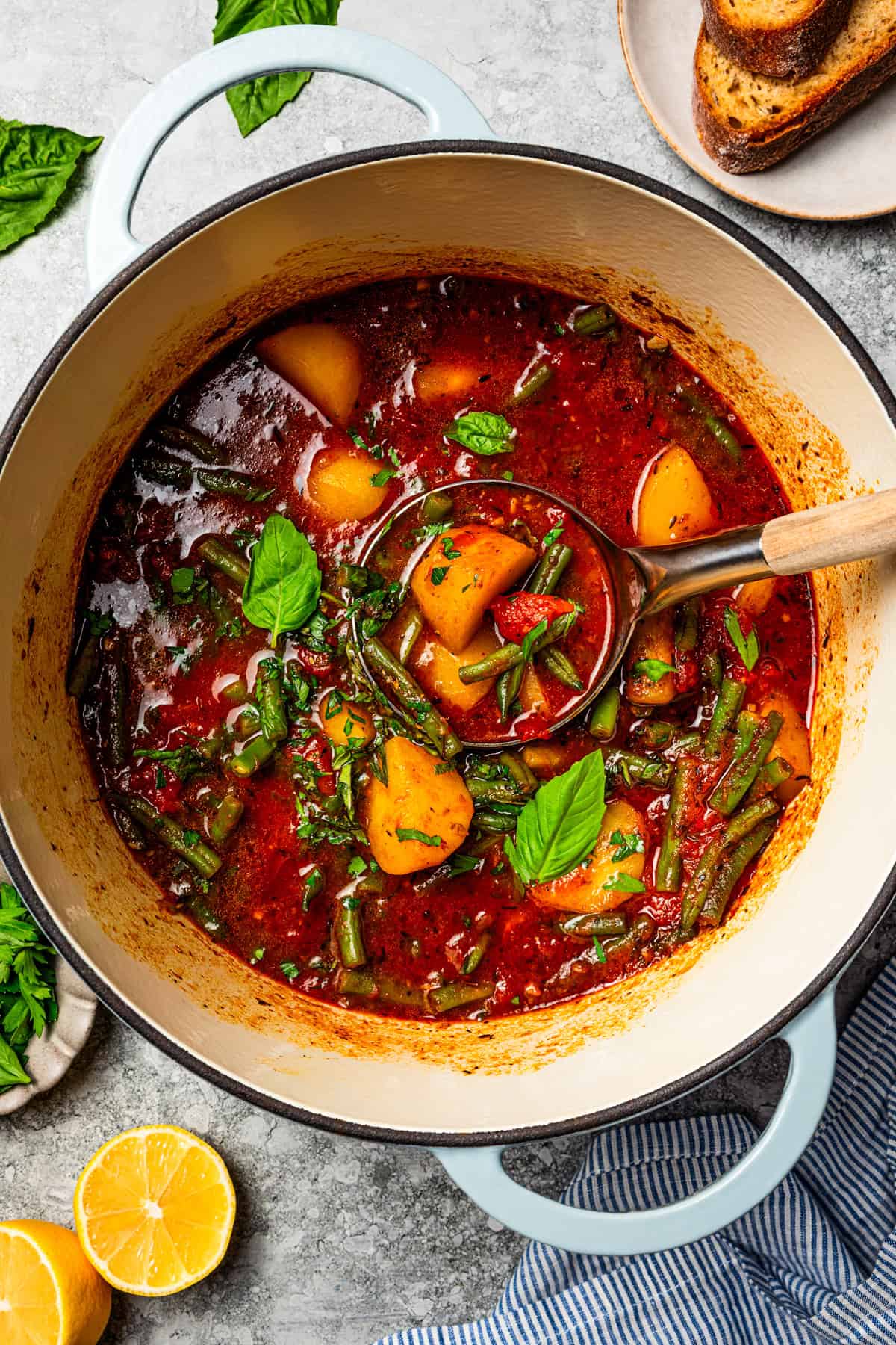 Braised potatoes are slow-cooked with tender green beans and tomatoes in this easy, one-pot Macedonian dish that warms from the inside out. Braised potatoes in a pot, with a ladle scooping out a serving.