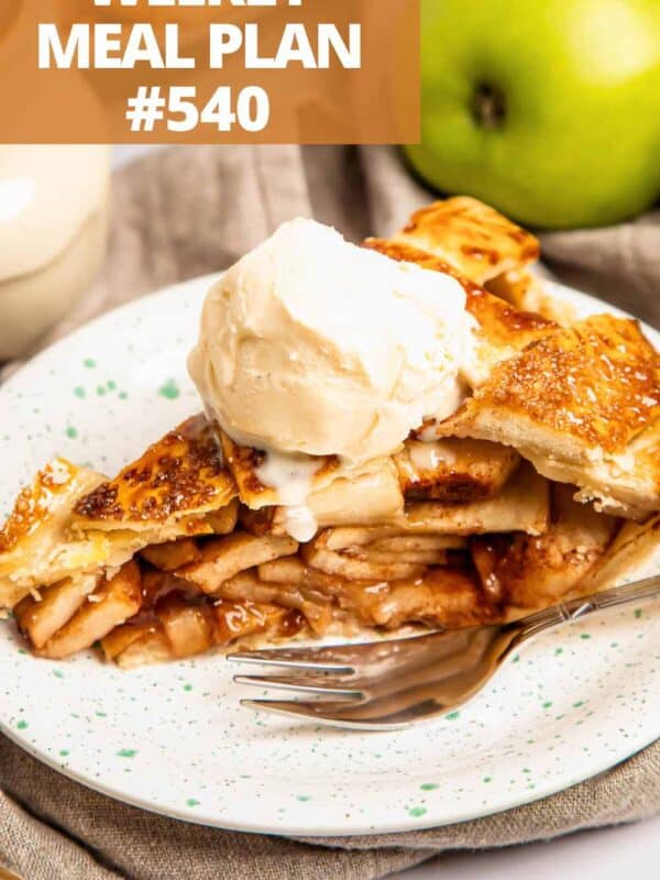 A slice of apple pie topped with a scoop of vanilla ice cream.