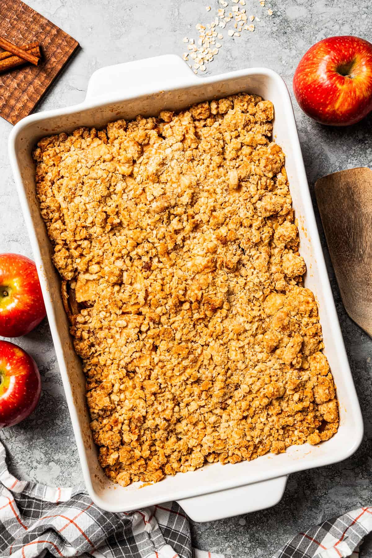 This old-fashioned apple crisp is a classic dessert, with apples, real apple cider, and warm spices baked under a light, crispy oat topping. A baked apple crisp in a large baking dish.