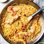 Creamy chicken and bacon pasta in a skillet.