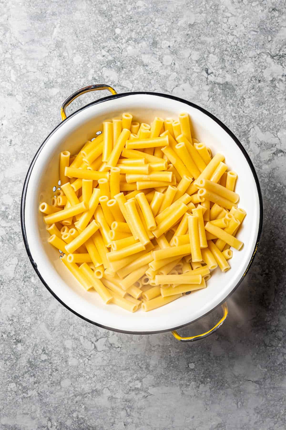 My easy baked ziti recipe is a weeknight-friendly pasta casserole with rich homemade meat sauce and three kinds of melty Italian cheese. Cooked ziti pasta in a colander.