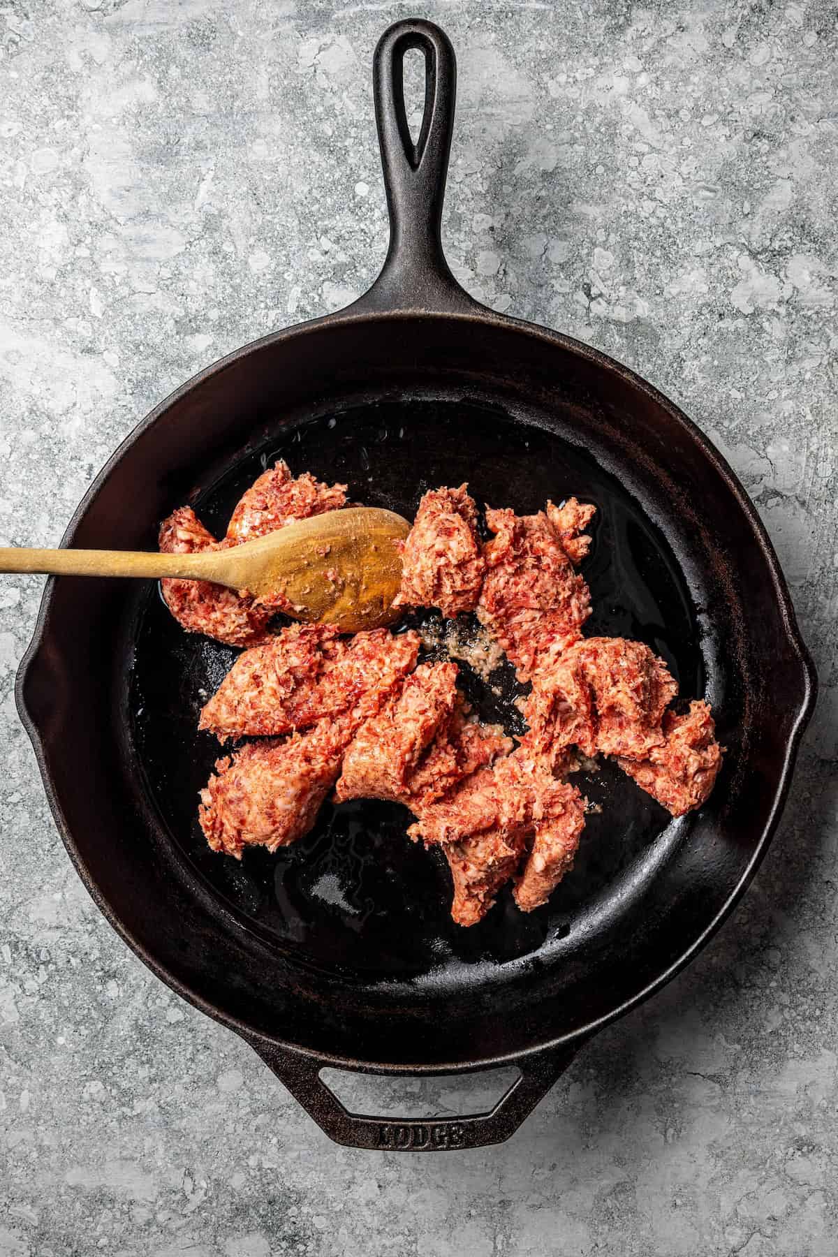 My easy baked ziti recipe is a weeknight-friendly pasta casserole with rich homemade meat sauce and three kinds of melty Italian cheese. Ground sausage broken up in a skillet.