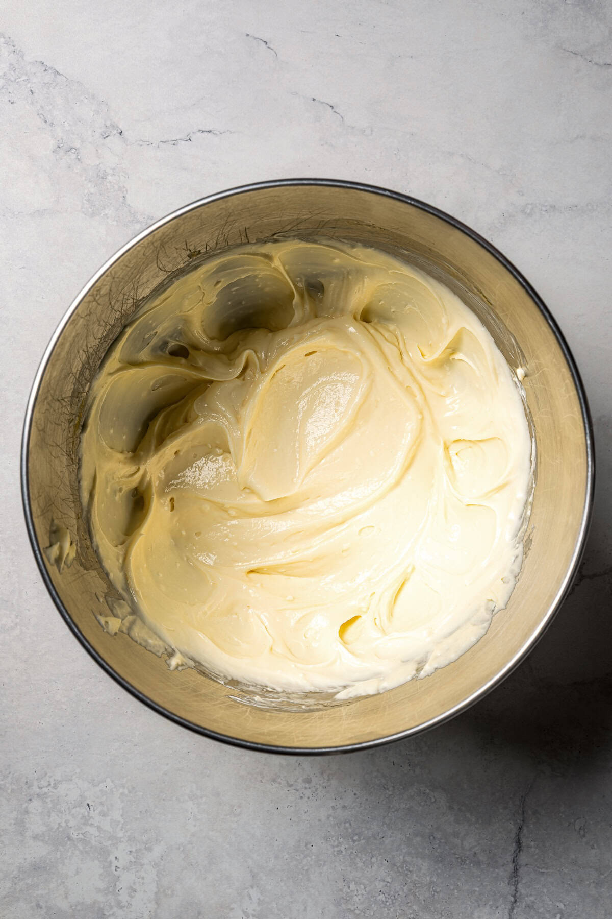 This churro cheesecake bars recipe is an easy dessert with layers of cinnamon sugar, a flaky pastry crust, and creamy cheesecake filling. Cheesecake filling in a bowl.