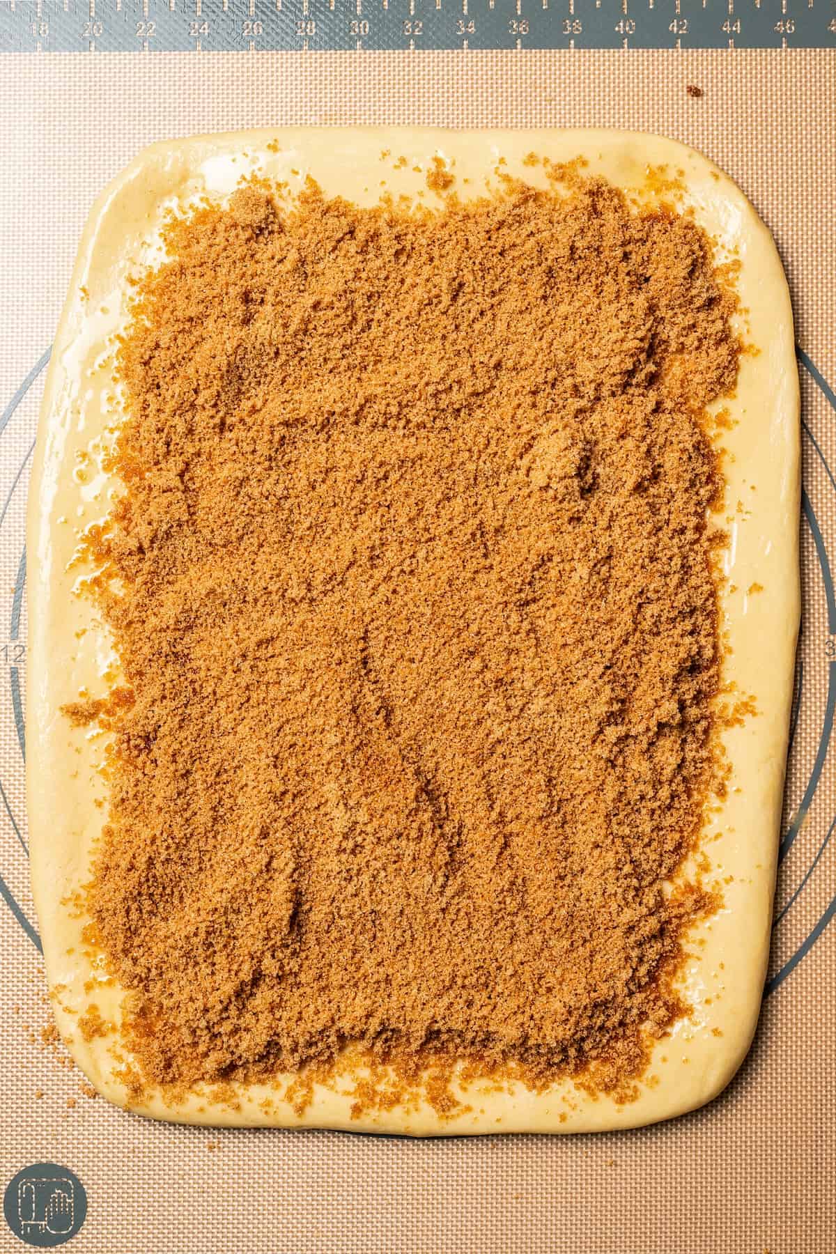 This cinnamon roll recipe makes big, bakery-style cinnamon buns filled with gooey cinnamon sugar and topped with sweet cream cheese frosting. Cinnamon sugar filling spread evenly over a rolled out dough rectangle.