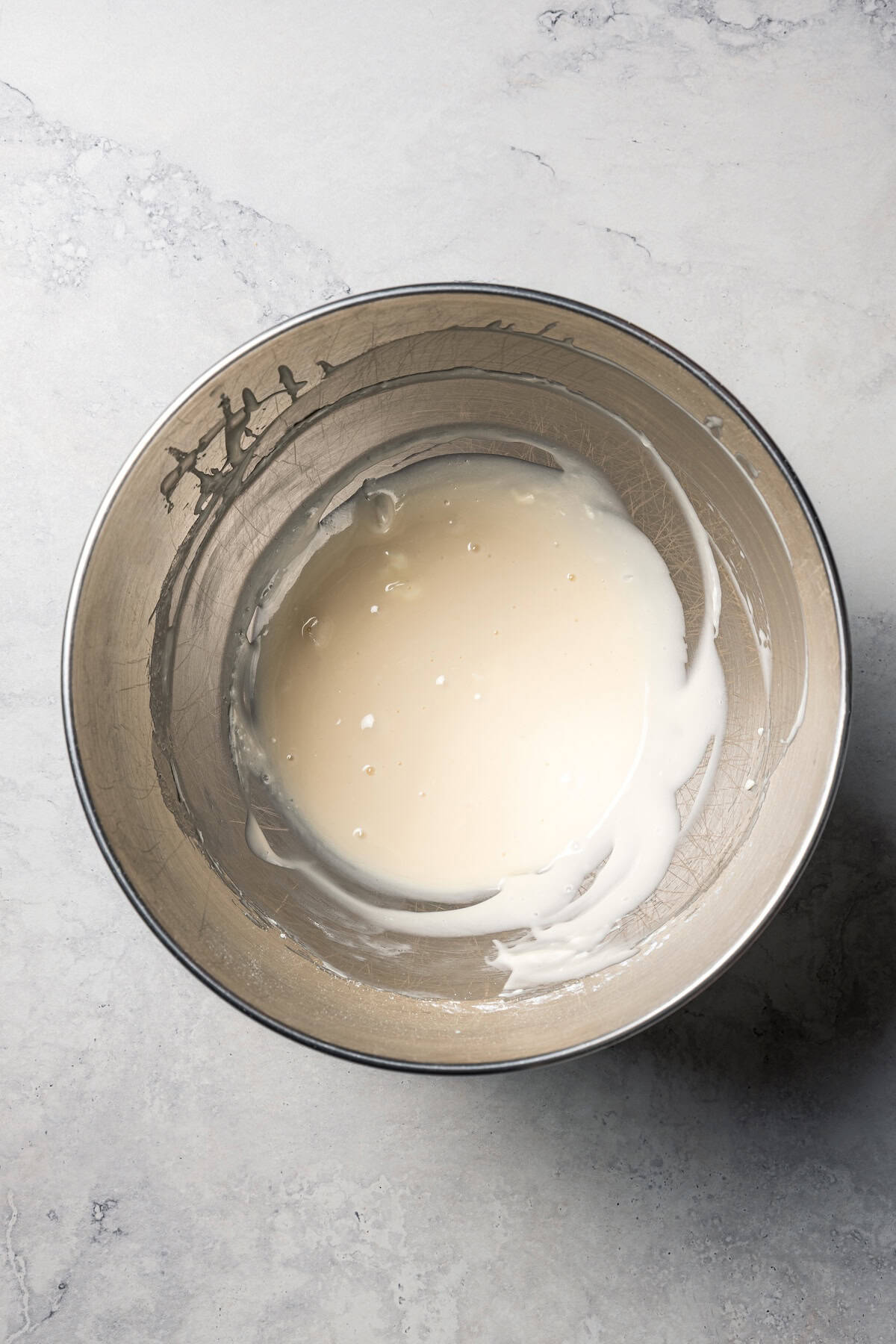 This cinnamon roll recipe makes big, bakery-style cinnamon buns filled with gooey cinnamon sugar and topped with sweet cream cheese frosting. Cinnamon roll icing in a mixing bowl.