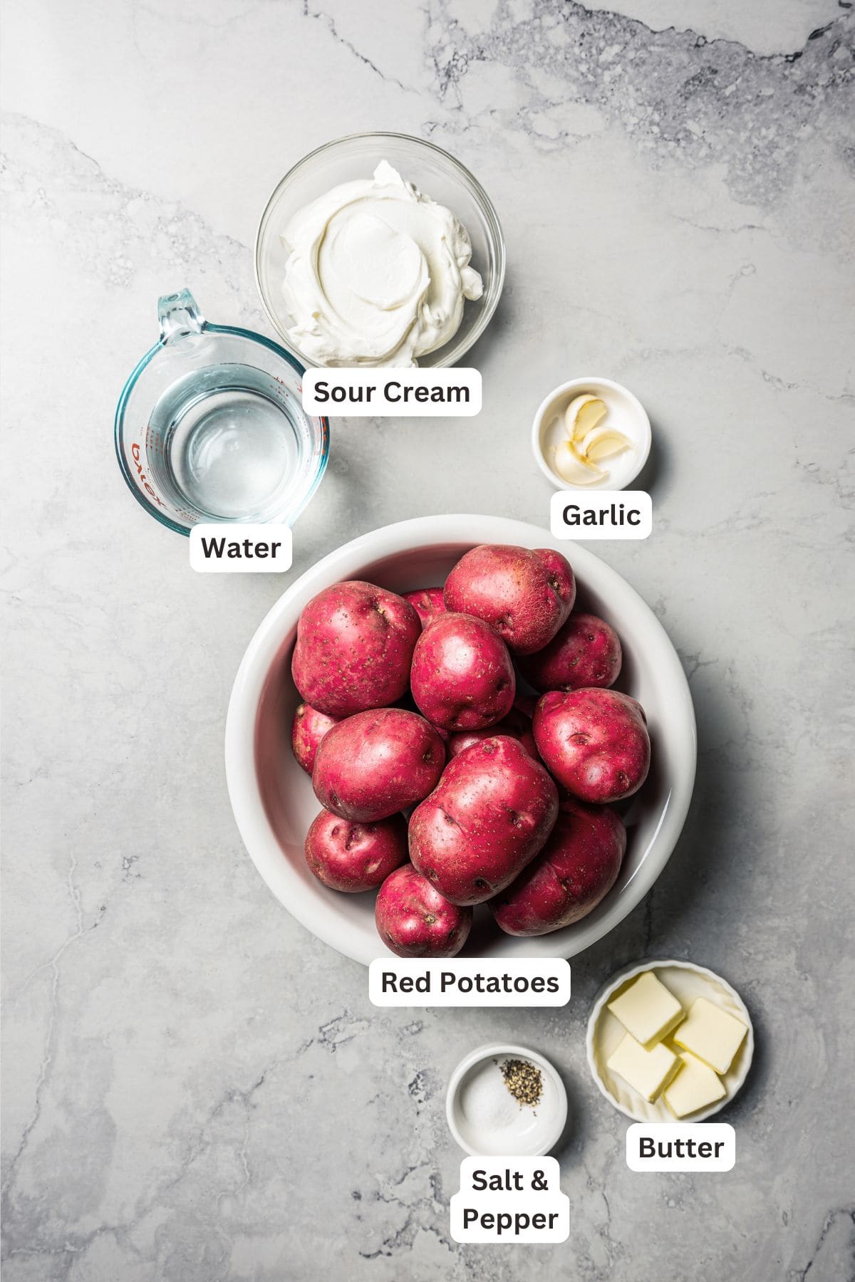 These slow cooker garlic mashed potatoes are made with creamy, skin-on red potatoes and plenty of butter! No boiling, and only 6 ingredients. Country garlic mashed potatoes ingredients with text labels overlaying each ingredient.