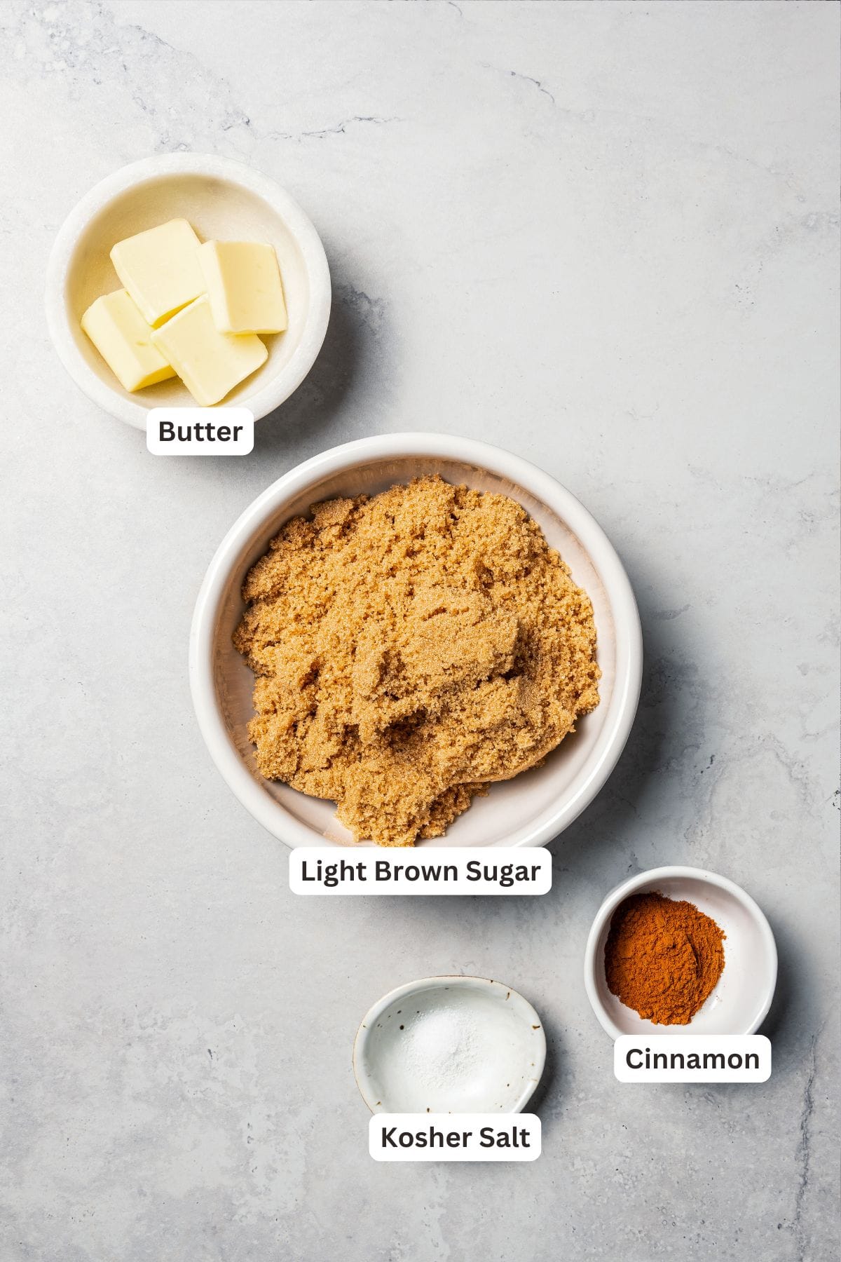 This cinnamon roll recipe makes big, bakery-style cinnamon buns filled with gooey cinnamon sugar and topped with sweet cream cheese frosting. Cinnamon roll filling ingredients with text labels overlaying each ingredient.