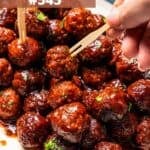 A bowl of grape jelly meatballs with toothpicks for easy grabbing.