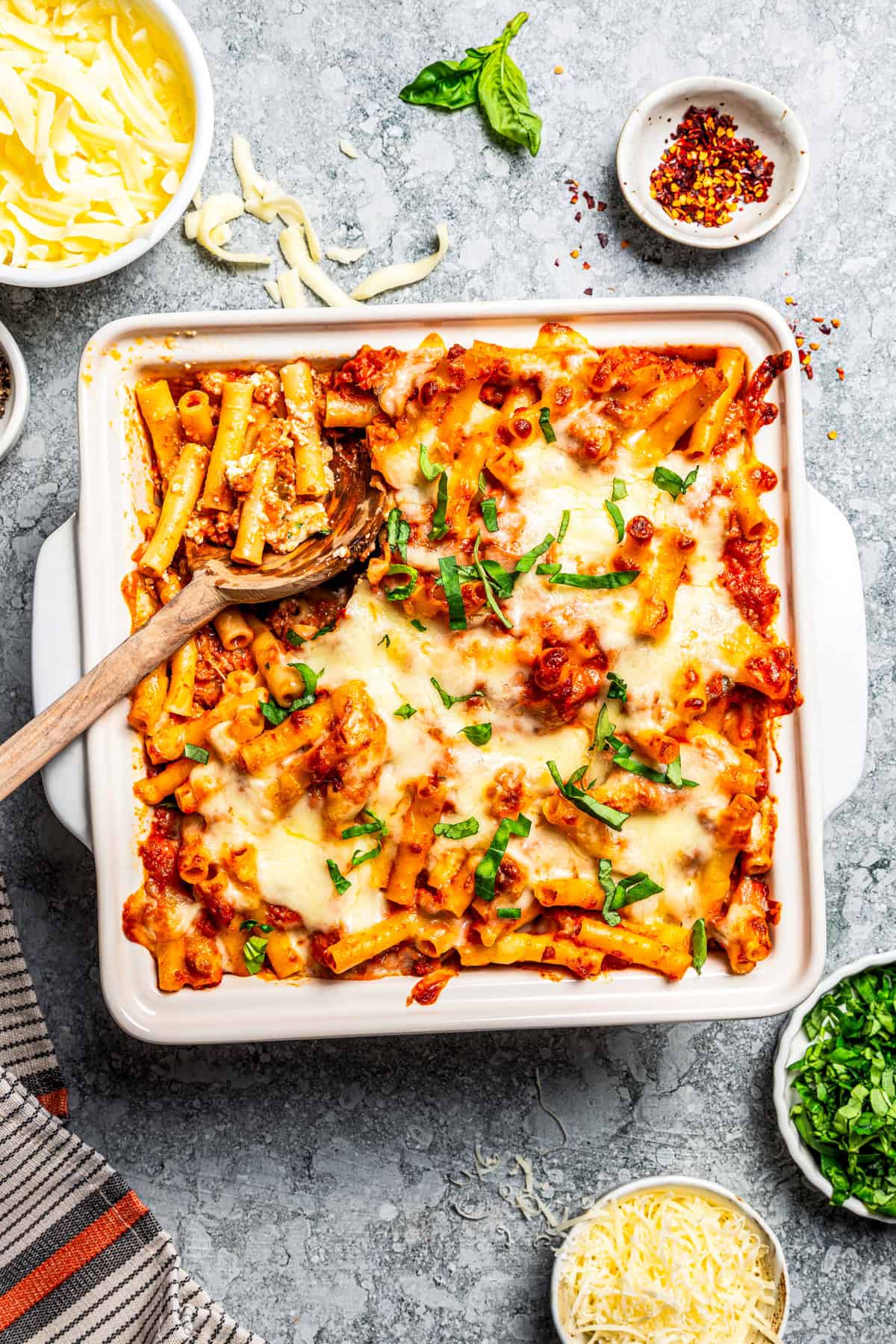 My easy baked ziti recipe is a weeknight-friendly pasta casserole with rich homemade meat sauce and three kinds of melty Italian cheese. Baked ziti in a casserole dish.