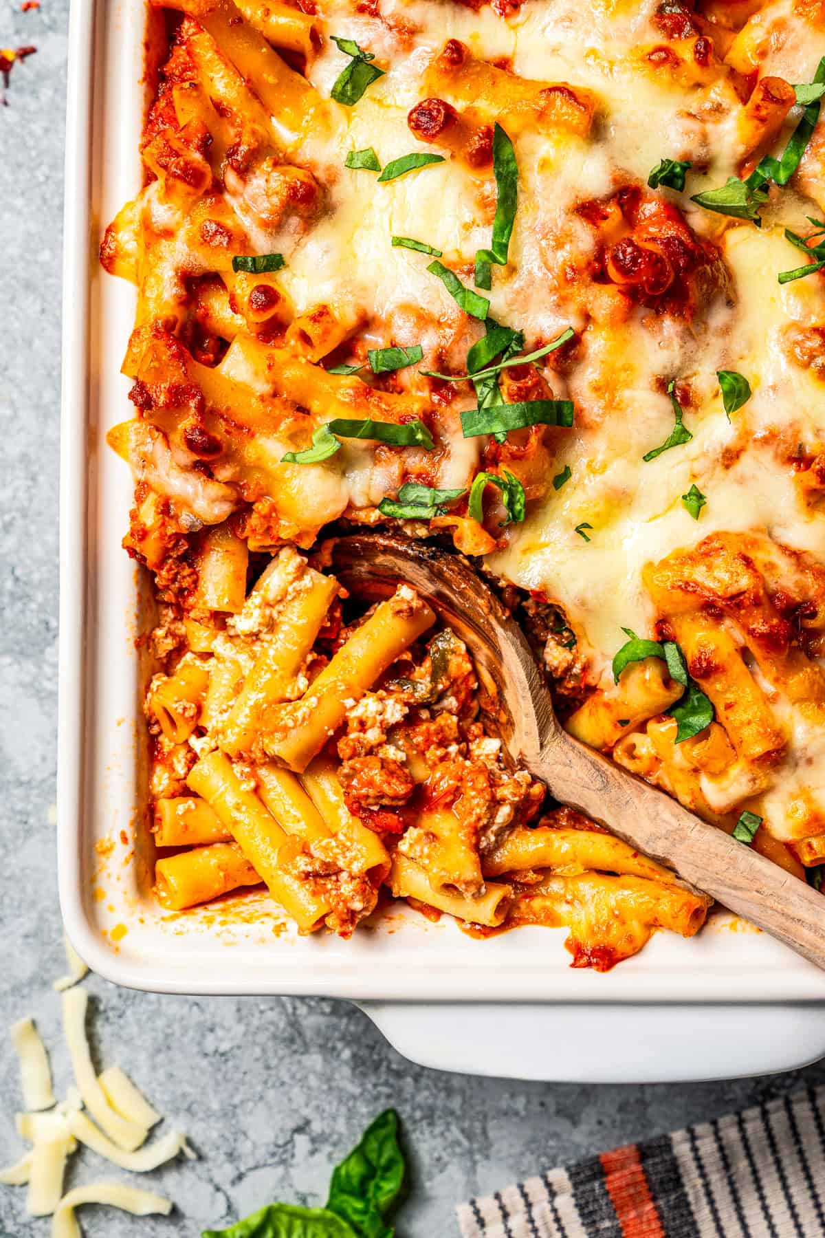 My easy baked ziti recipe is a weeknight-friendly pasta casserole with rich homemade meat sauce and three kinds of melty Italian cheese. Spoon resting in a casserole dish of baked ziti.