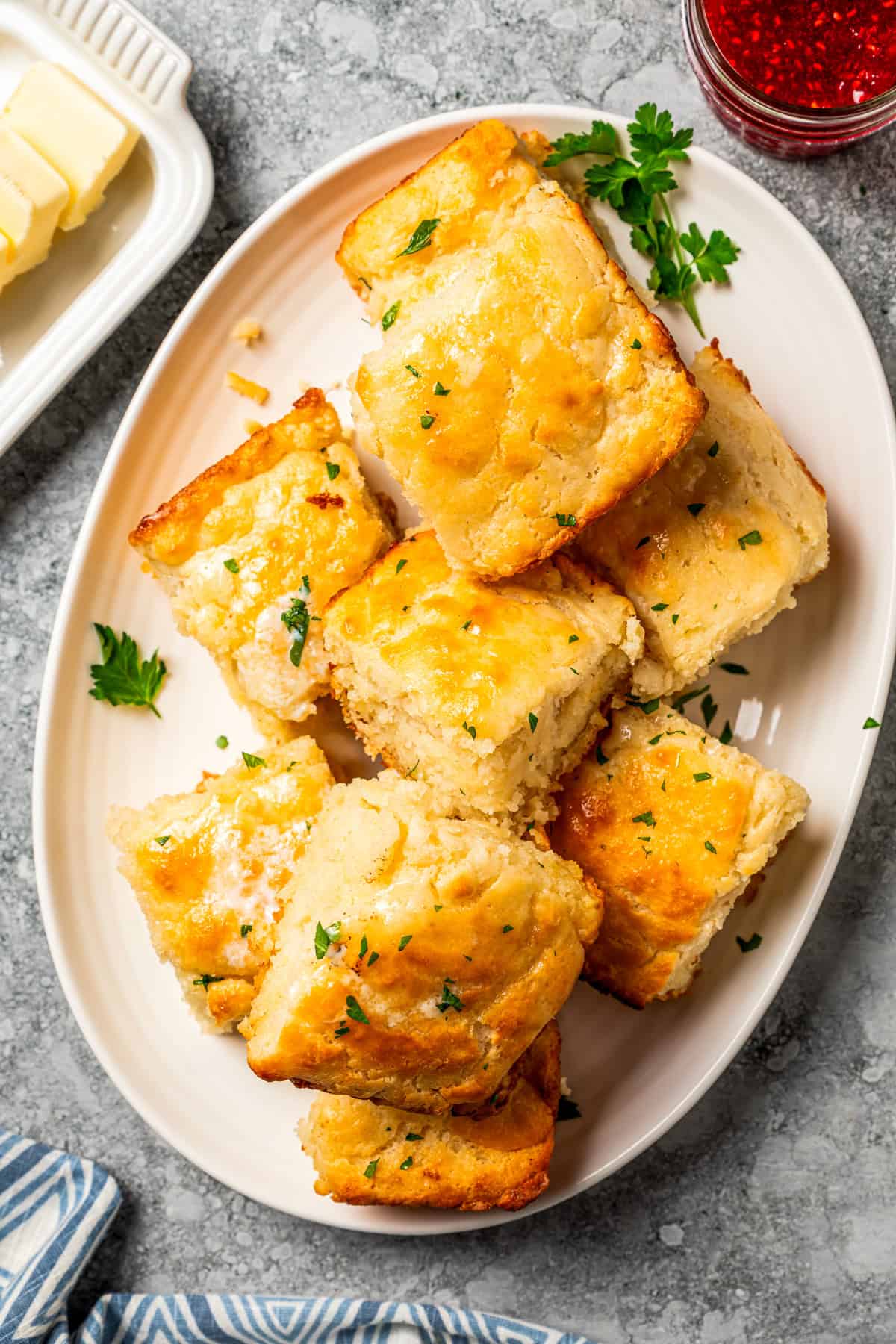 Butter swim biscuits are fluffy drop biscuits baked in a pool of butter! Crispy outside, soft inside, and easy to make with 5 ingredients. Biscuits stacked on a platter.