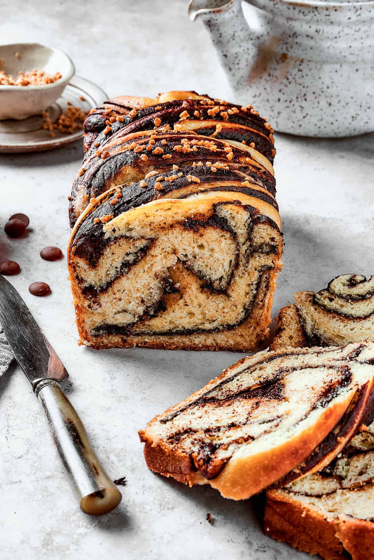 Homemade chocolate babka cut into slices on a light surface.