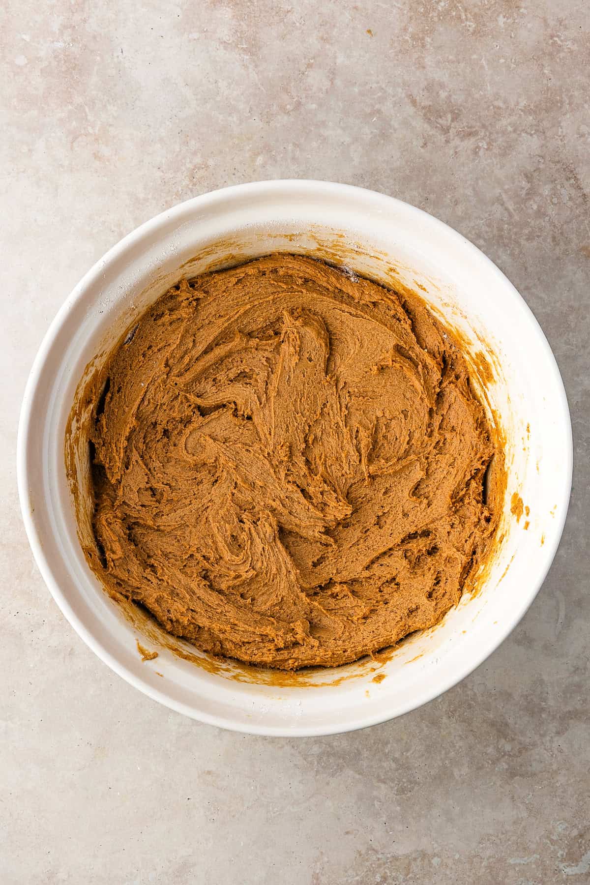 Thick, chewy, and soft gingerbread cookies flavored with warm spices and molasses. They're festive, cozy, and so easy to make for the holidays. A bowl of cookie dough for gingerbread cookies.