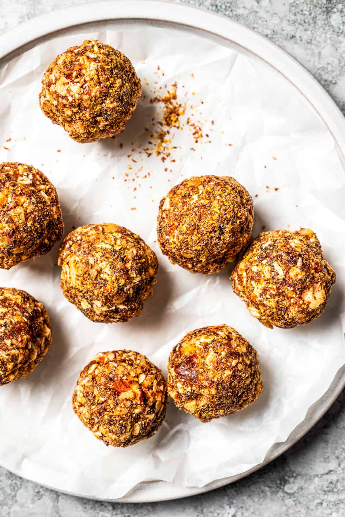 These gingerbread energy bites taste just like gingerbread cookie dough! Make them in the blender with sticky dates, oats, nuts, and spices. Gingerbread energy bites arranged on a plate.
