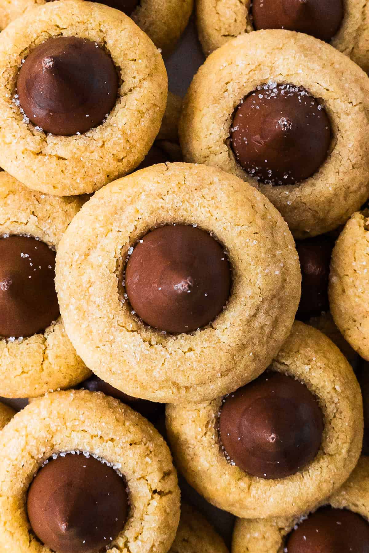 This peanut butter blossoms recipe makes soft, thick peanut butter cookies topped with a chocolate kiss. Easy to make and perfect for any occasion. Overhead shot of a stack of peanut butter blossom cookies.