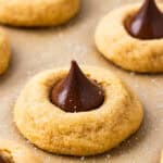 Peanut butter blossoms arranged on parchment paper.