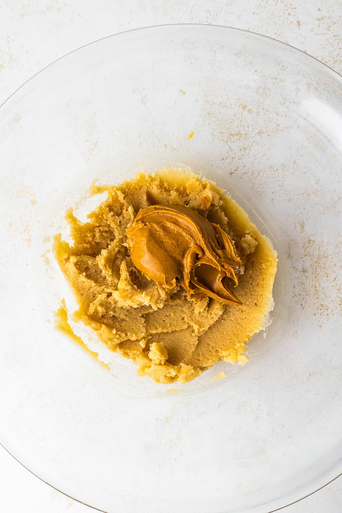 This peanut butter blossoms recipe makes soft, thick peanut butter cookies topped with a chocolate kiss. Easy to make and perfect for any occasion. Adding peanut butter to cookie dough.