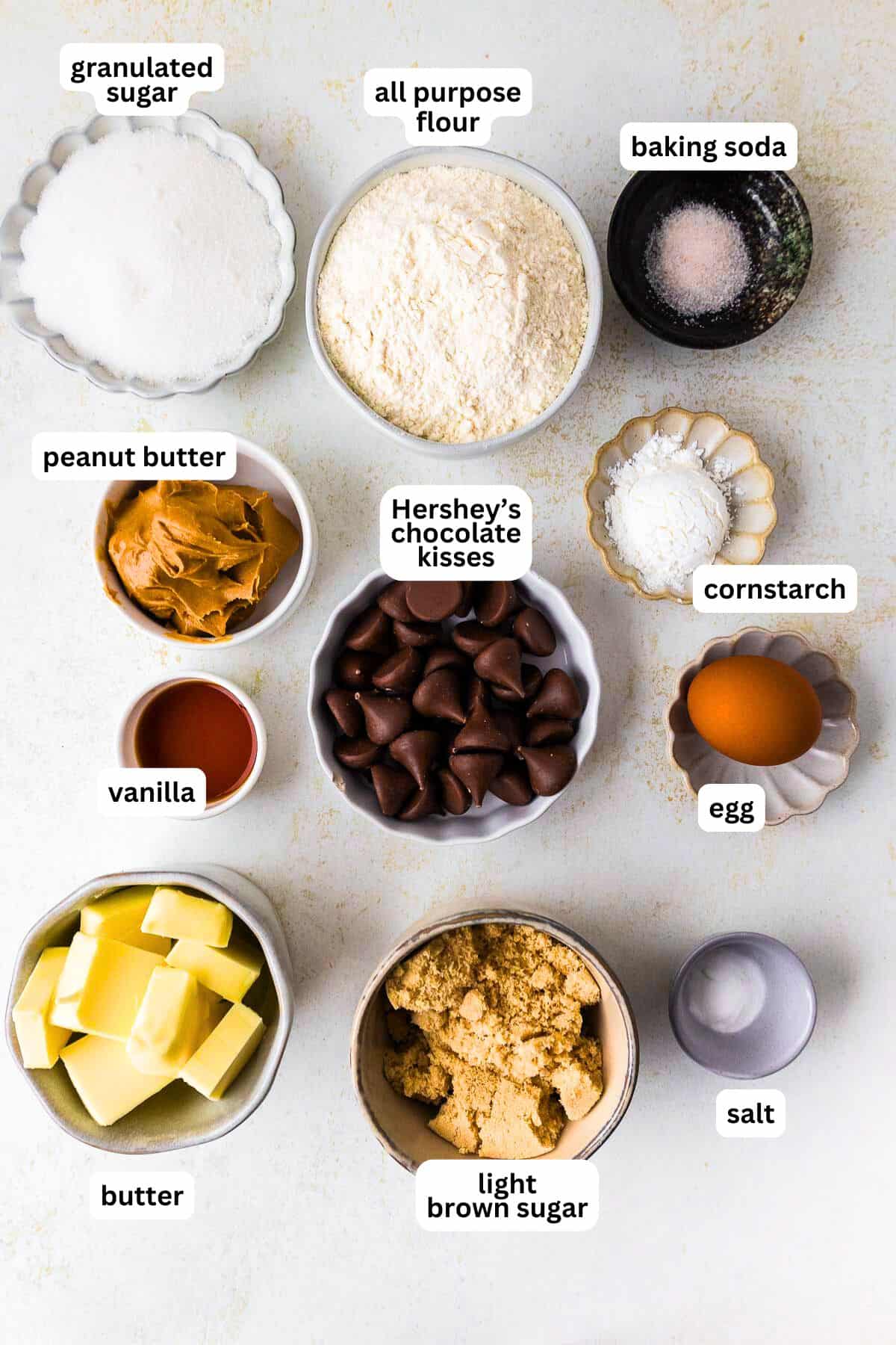 This peanut butter blossoms recipe makes soft, thick peanut butter cookies topped with a chocolate kiss. Easy to make and perfect for any occasion. A photo of peanut butter blossoms ingredients with text overlays.