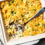 A spoon resting in the corner of a tuna casserole in a baking dish.