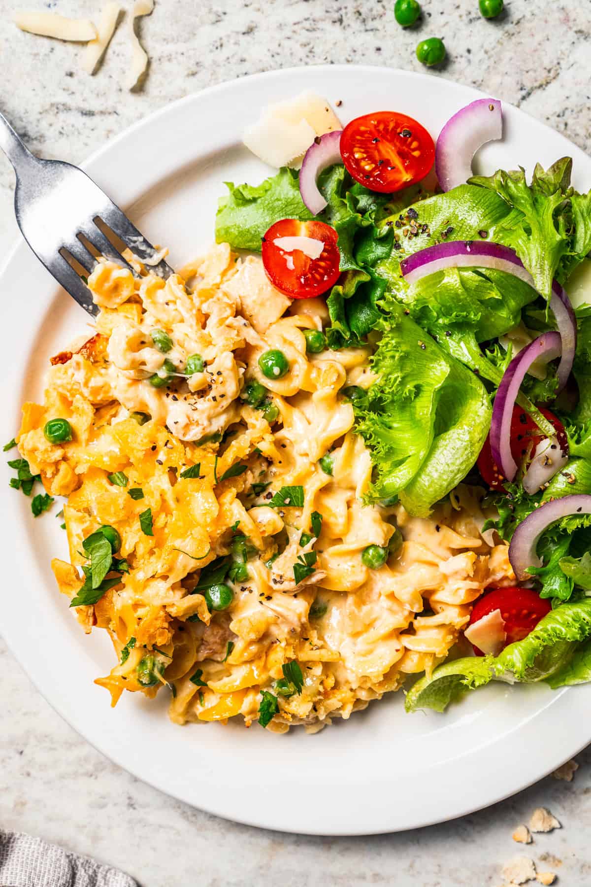 Tuna noodle casserole served on a plate with a side salad.