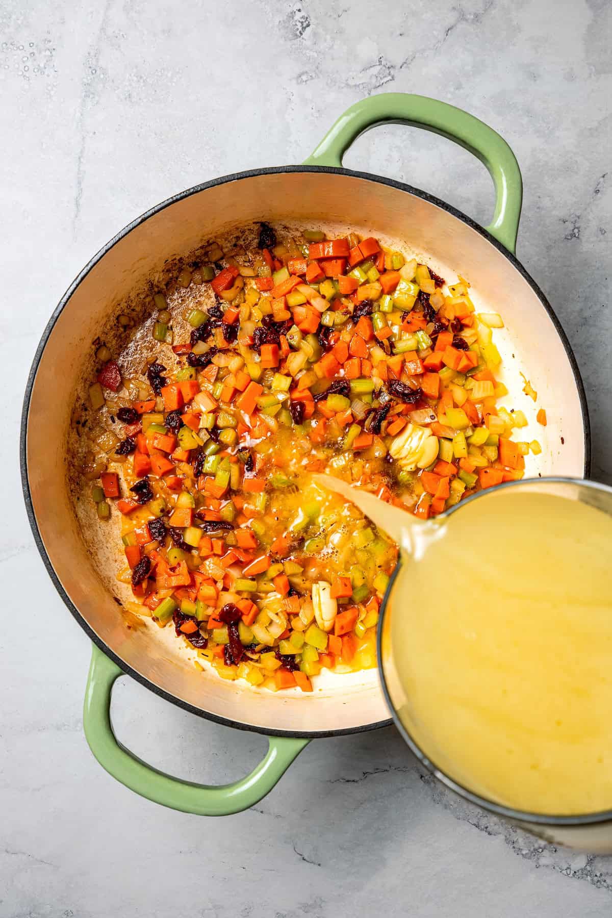 This chicken gnocchi soup is even better than the Olive Garden! It's ready in 20 minutes, extra creamy, and packed with flavorful ingredients. Broth being poured into a soup pot with the other ingredients.