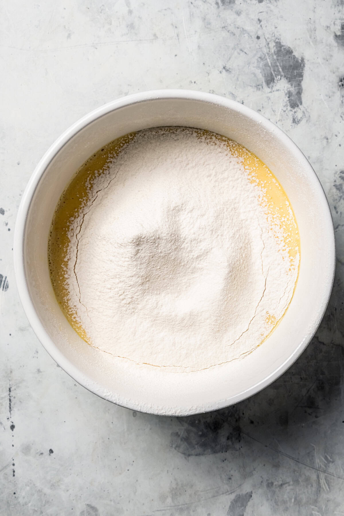 This German pancake recipe takes minutes to prepare and bakes up super soft, puffed, and golden in the oven. Made with only 6 ingredients! Dry ingredients sifted into a bowl of wet batter.