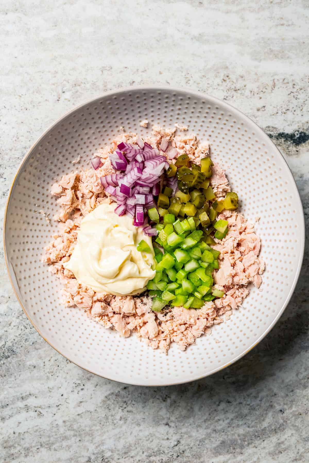 Tuna salad ingredients combined in a bowl.