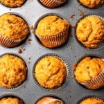 Baked apple sauce muffins in a muffin tin.