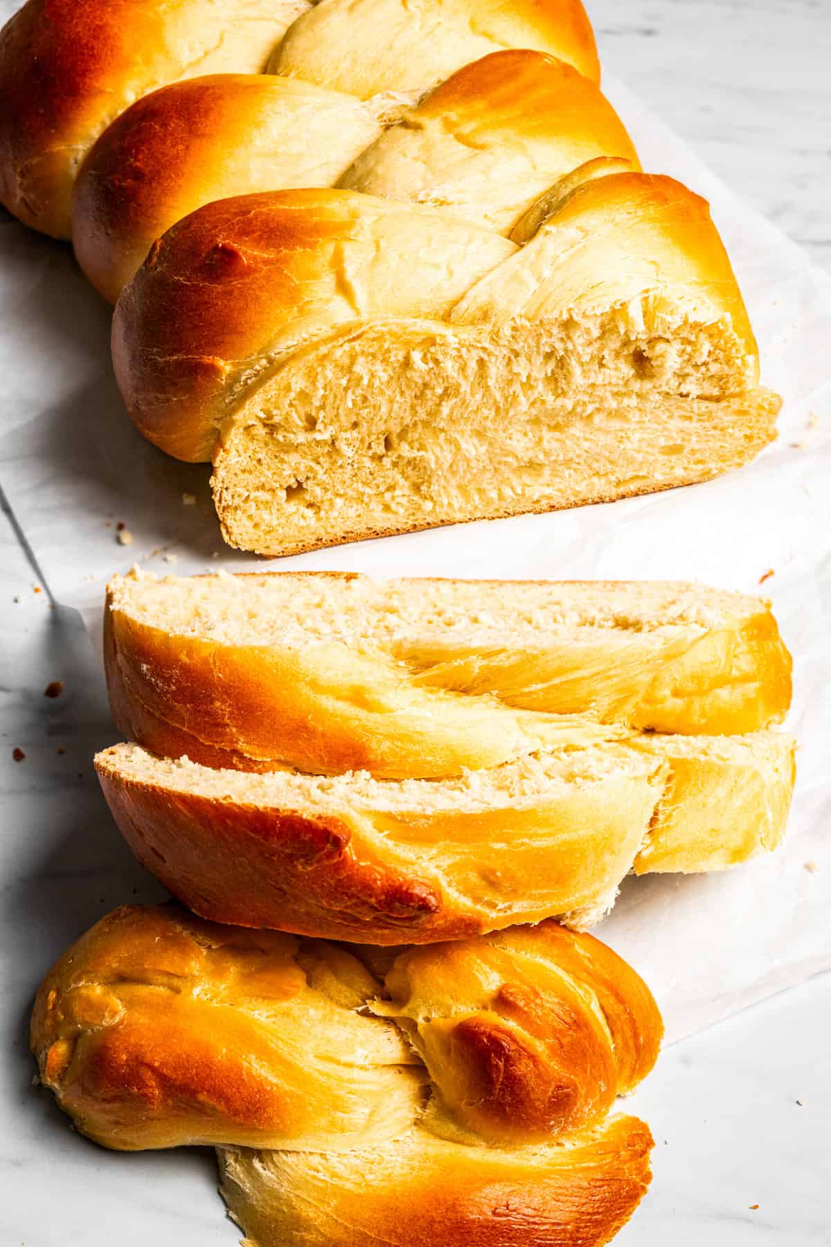 A loaf of challah with slices cut from the end.